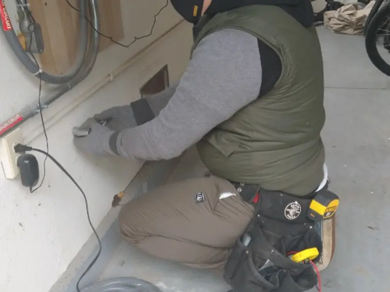 Electrician performing outlet wiring in a Barberton garage